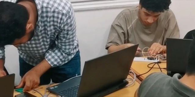 Students wiring boards in a workshop